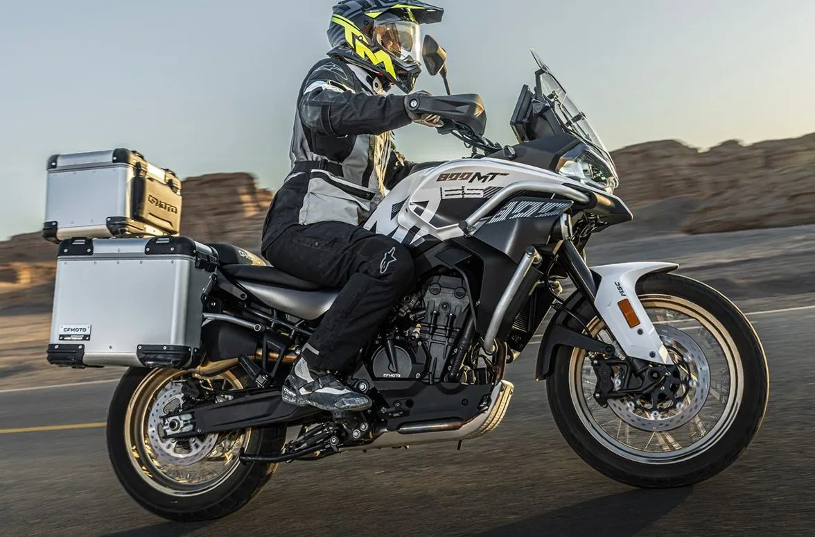 Une moto CFMOTO 800MT-ES sur une route avec des valises et un top-case
