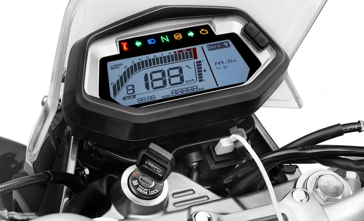 Le tableau de bord de la moto Hero Xpulse 200 Pro, une clé de contact et un cable blanc dans une prise USB