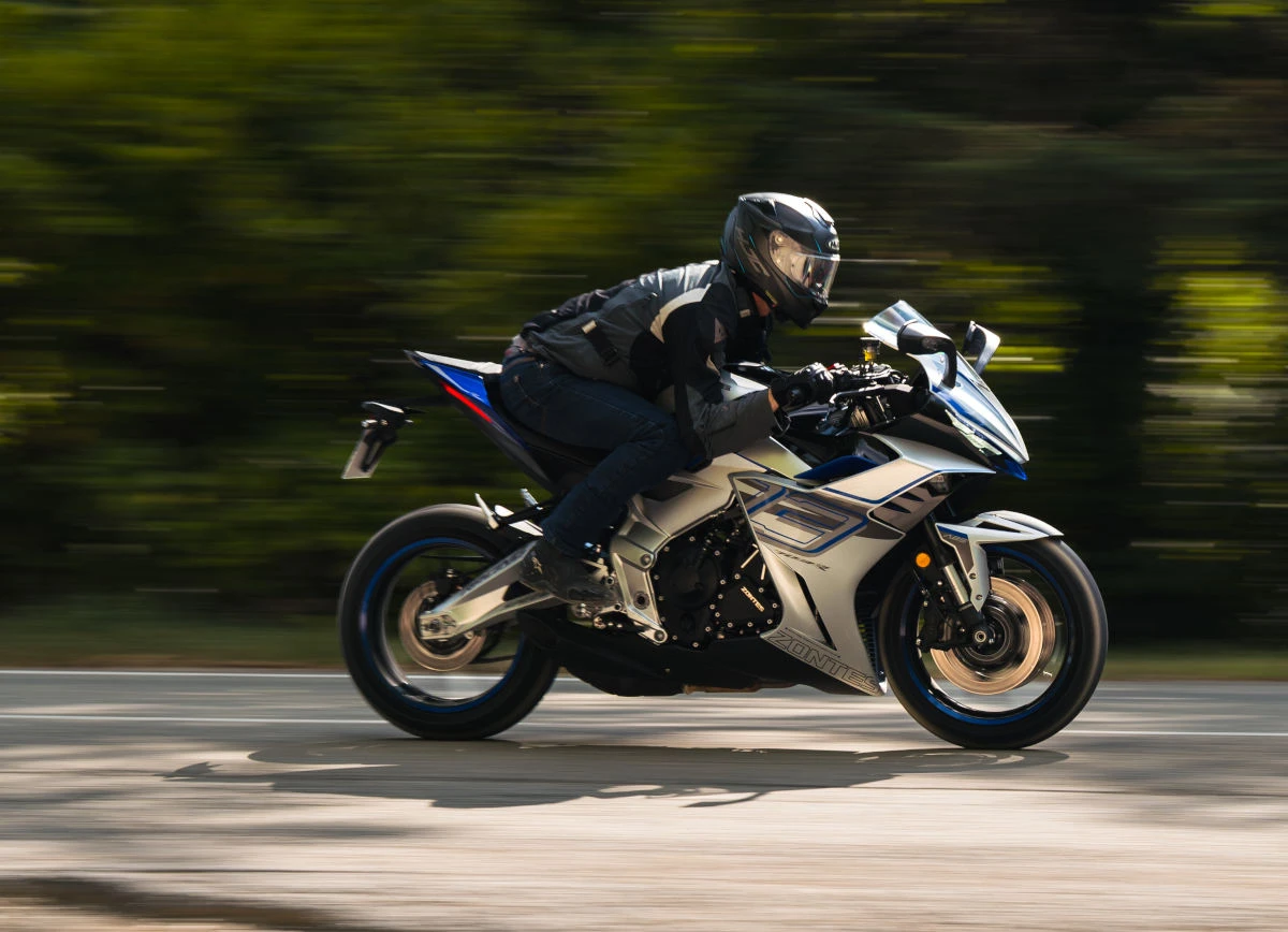 La moto file à vive allure dans une zone boisée