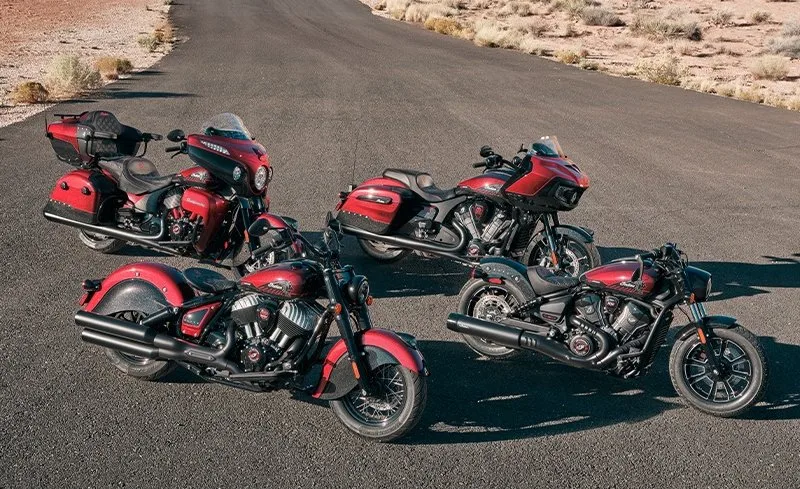 4 motos rouge et noire de la marque Indian, une large route et un sol aride de chaque coté.