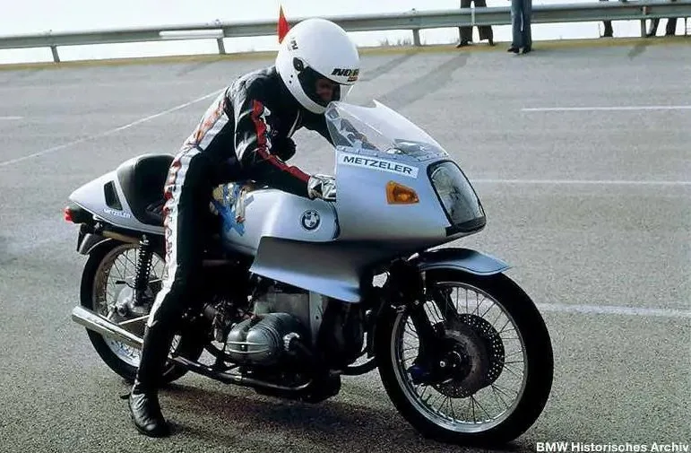 Une moto BMW R 100 RS sur le circuit de Nardo, un pilote en combinaison noir et un casque blanc