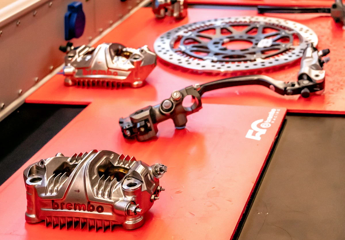 Des éléments de freinage Brembo de MotoGP sur une table d'atelier rouge