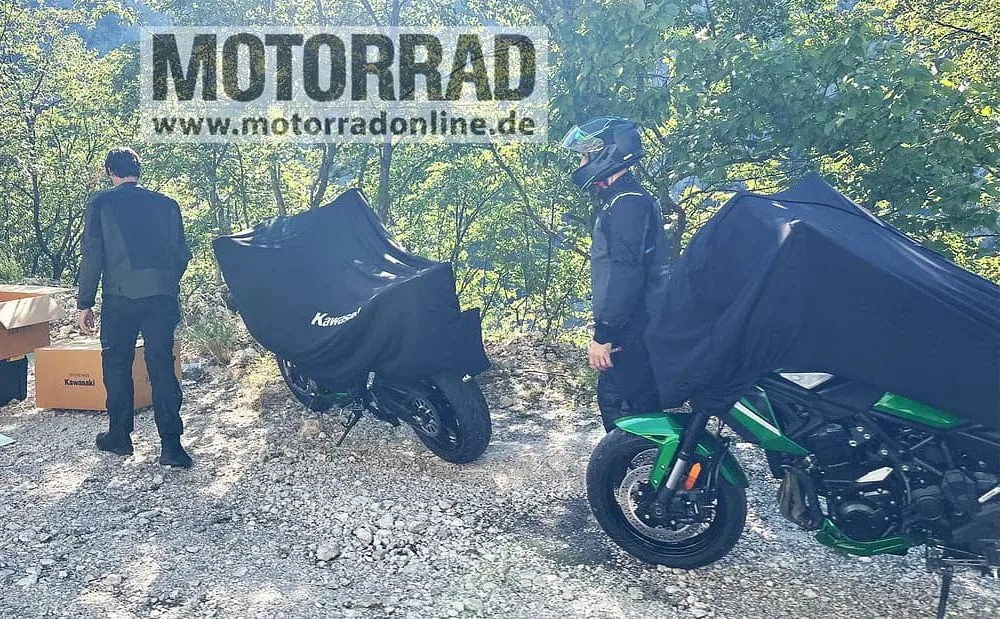 Deux Kawasaki Versys 900 cachée par des baches noires, le mot Motorrad, deux motards et une foret