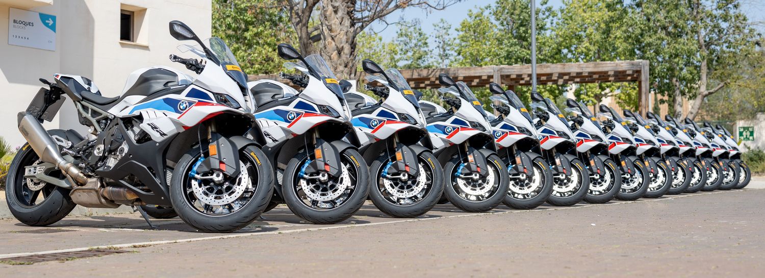 Several BMW S 1000 RR motorcycles lined up in a parking lot