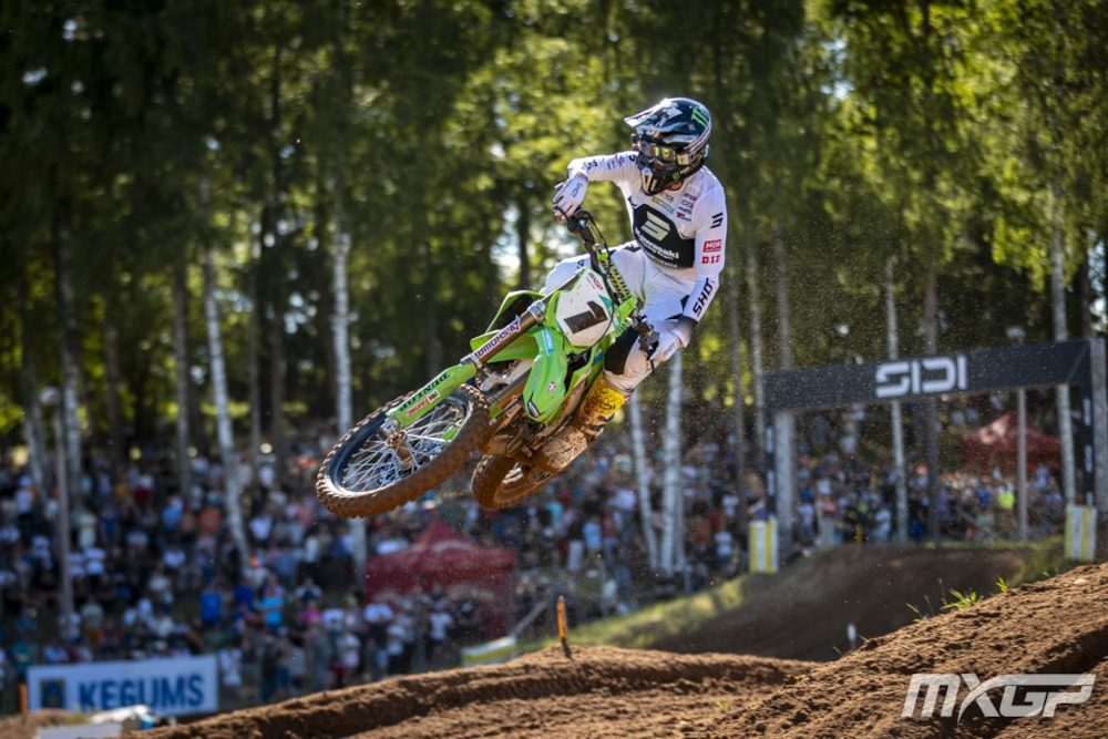 Romain Febvre soaring through the air on his green Kawasaki in his white outfit