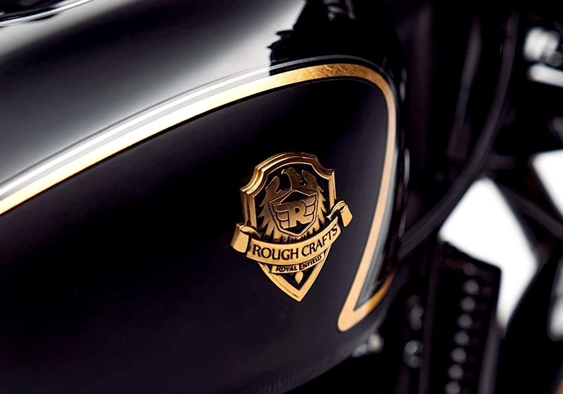 un écusson Rough Crafts doré en laiton sur un réservoir noir de Royal-Enfield 650 Shotgun