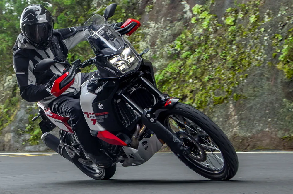 Une Yamaha 700 Ténéré World Raid 2026 sur l'angle roulant sur une petite route